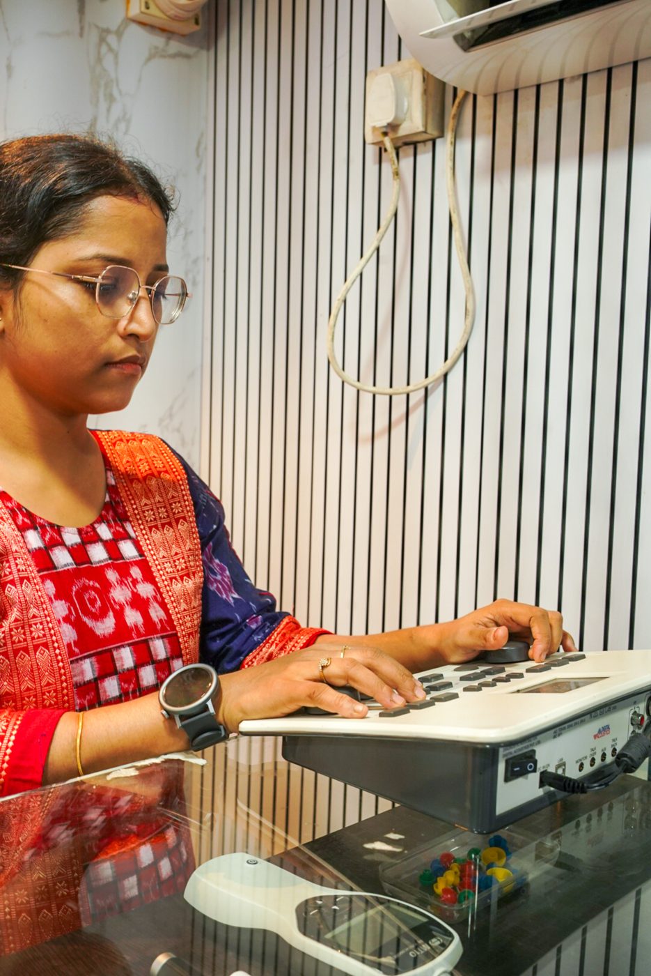 Audiologist operating diagnostic audiometry equipment